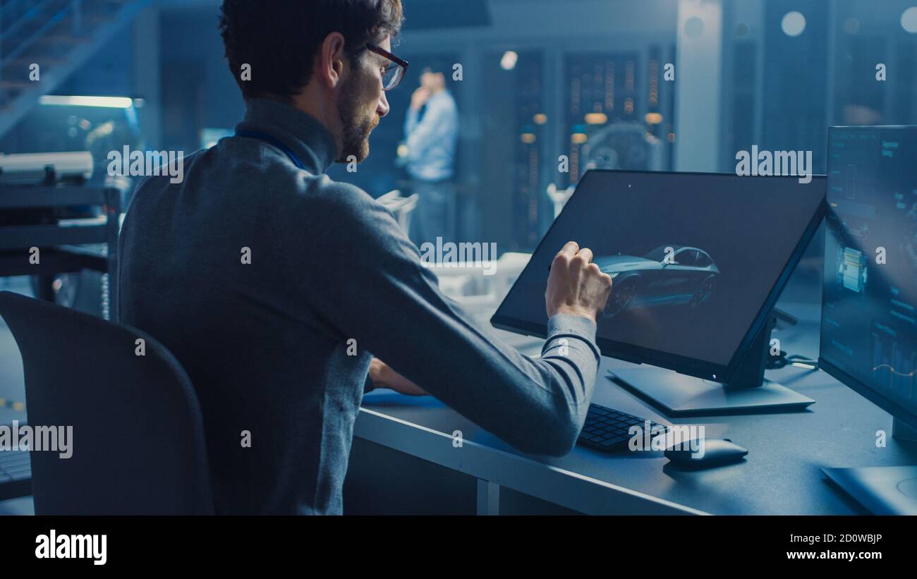 Professional Automotive Graphic Designer travaille sur le concept car Render Avec un stylet dans un laboratoire innovant de haute technologie Avec une voiture prototype Banque D'Images