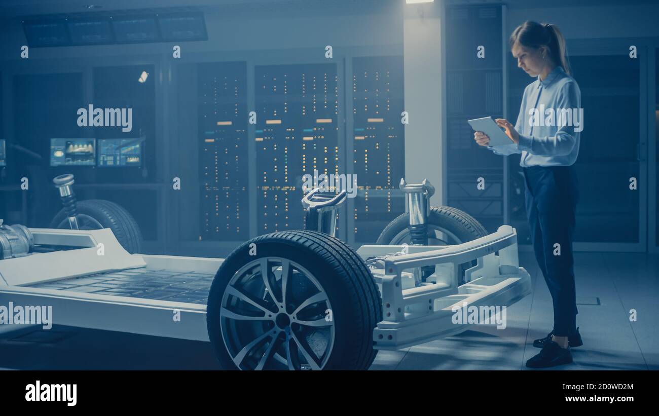 Ingénieur automobile travaillant sur la plate-forme de châssis de voiture électrique, utilisant la réalité augmentée d'ordinateur de tablette avec la modélisation de logiciel de CAO 3D. Innovant Banque D'Images