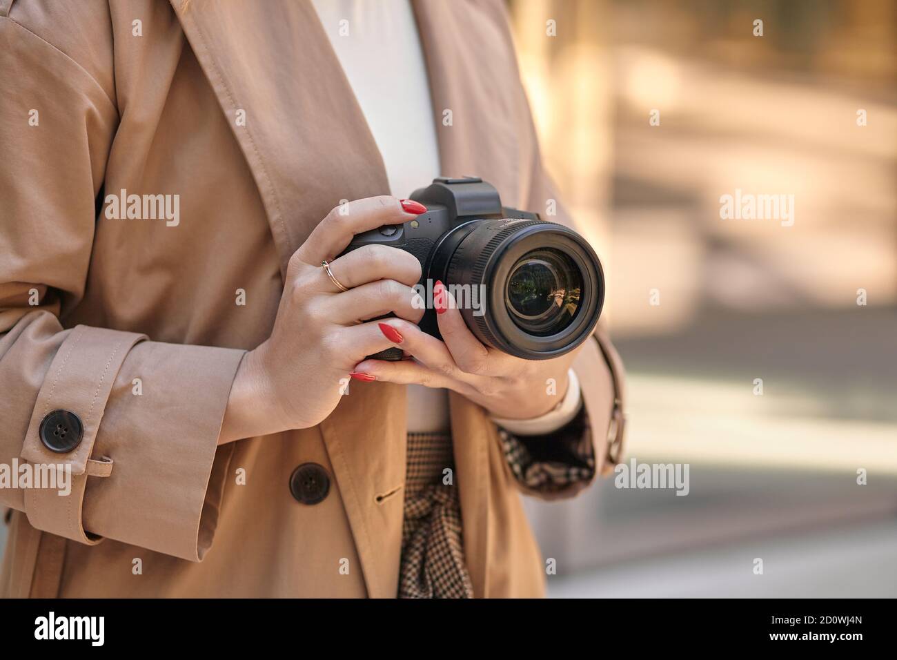 Femme en gros plan tenant un appareil photo professionnel, beige Banque D'Images