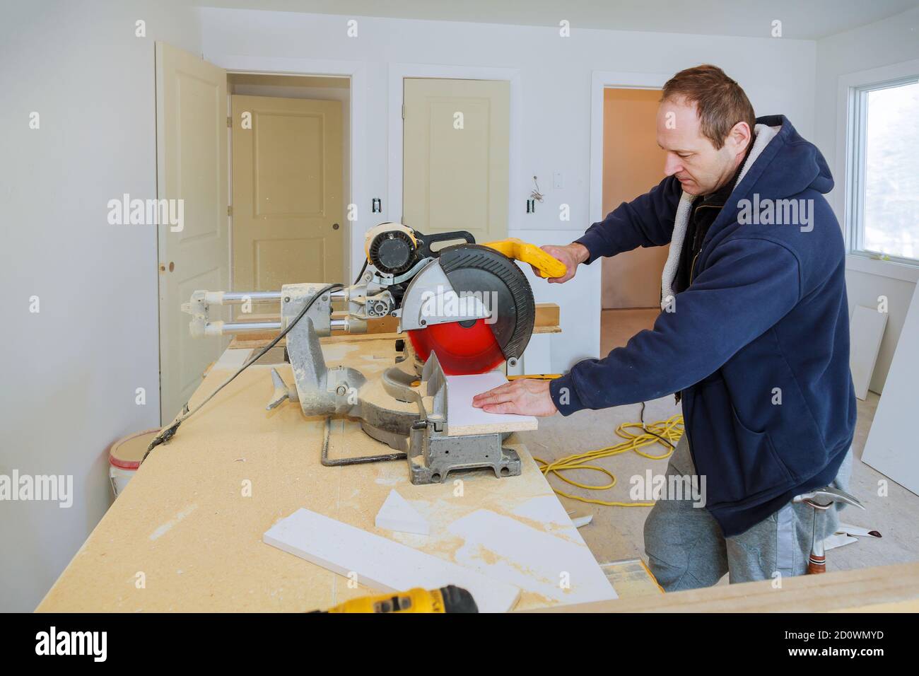 Builder utilise une scie circulaire pour couper les boiseries de plinthe en  bois équipement Photo Stock - Alamy
