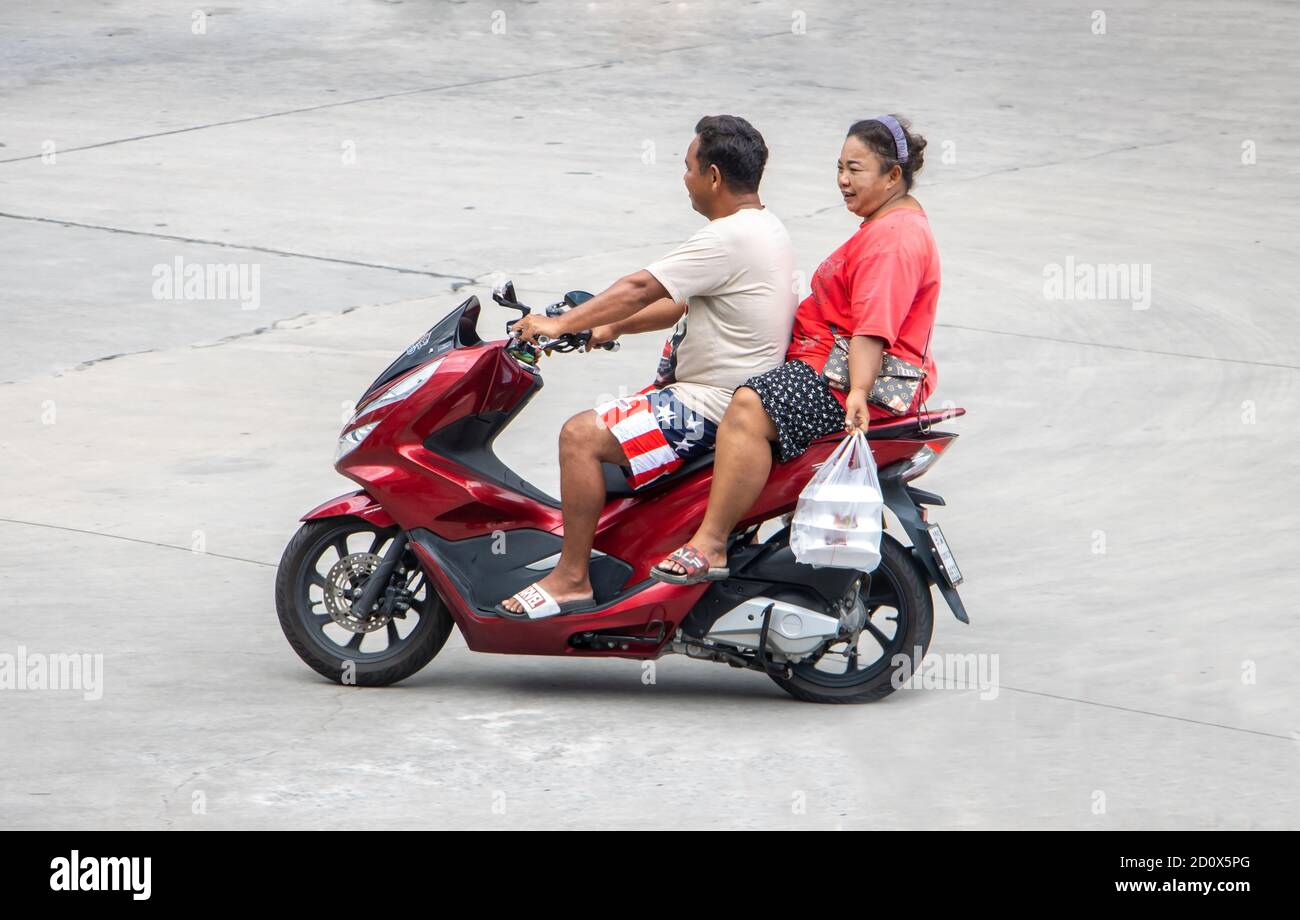 SAMUT PRAKAN, THAÏLANDE, JUILLET 25 2020, une paire avec des sacs en plastique du marché des promenades en moto dans la rue. Banque D'Images