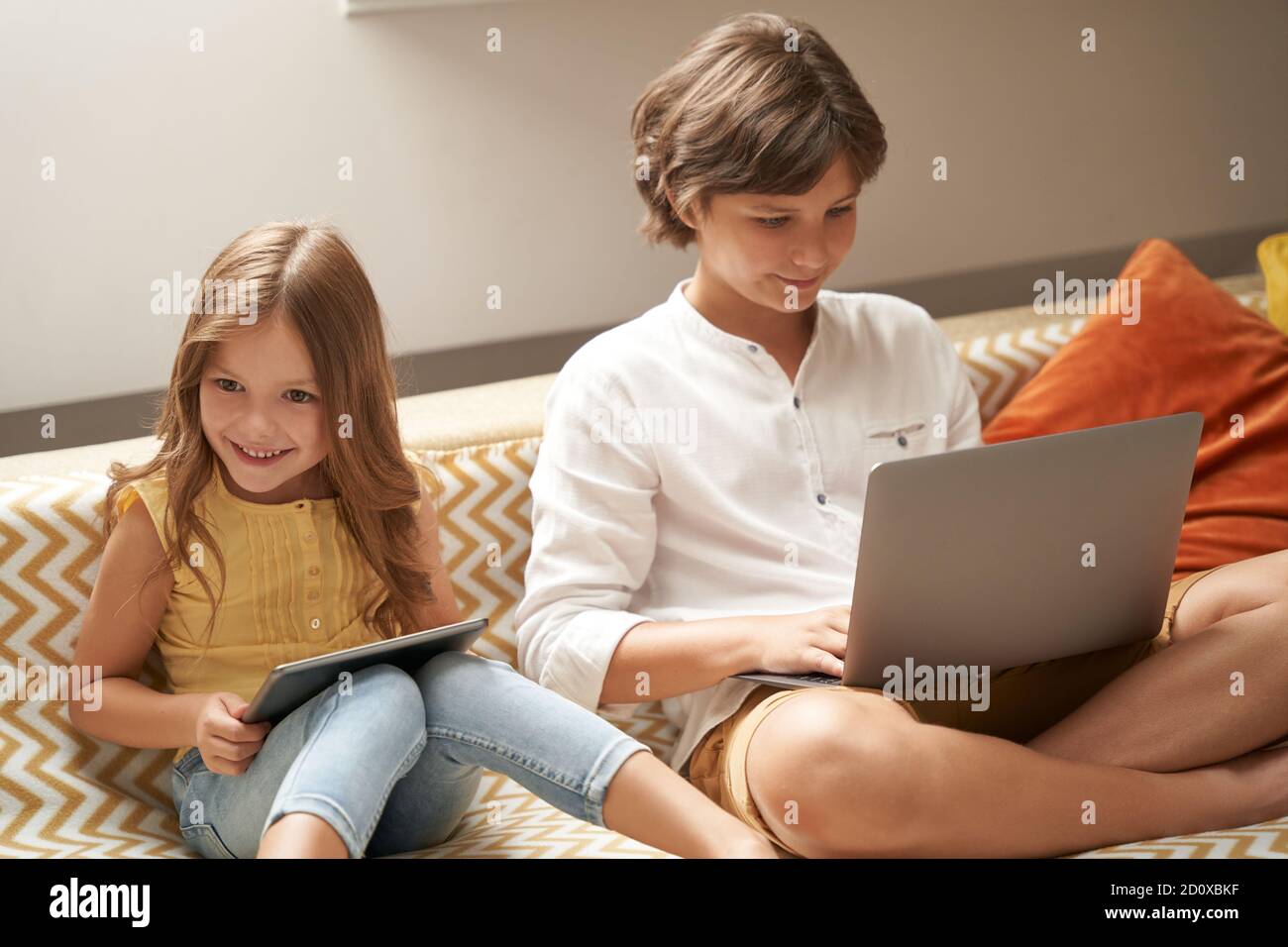 petite fille et sa mère à l'aide d'une tablette assise sur un