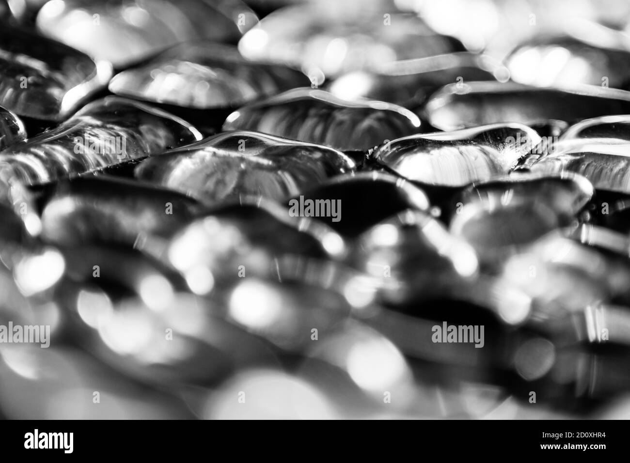 Photo en gros plan noir et blanc des pierres de verre réfléchissantes la lumière Banque D'Images
