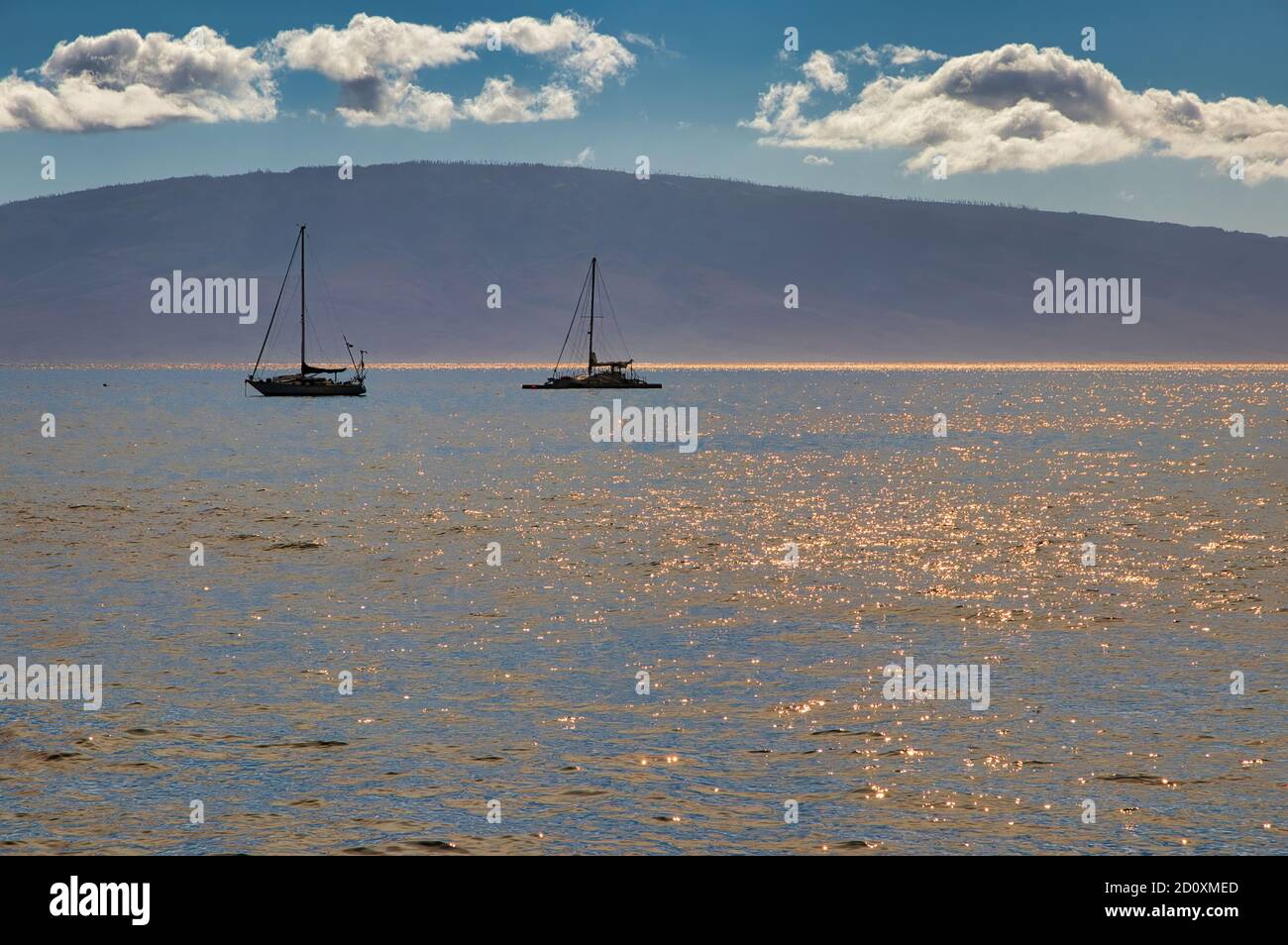 Vue téléobjectif sur Lanai et bateaux vus de Maui. Banque D'Images