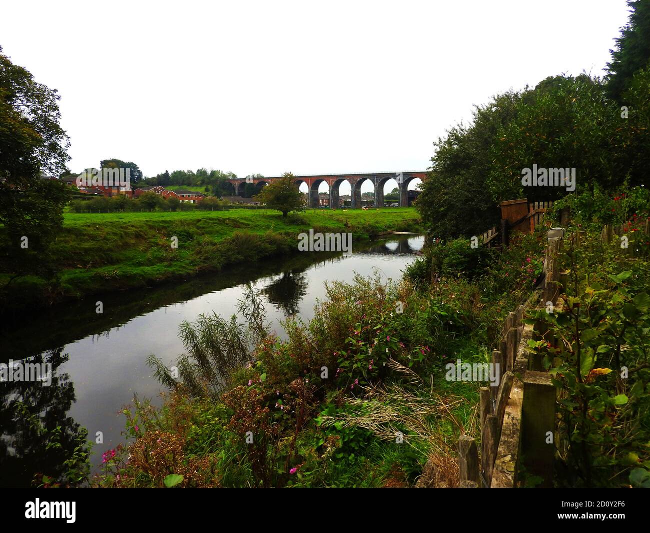 Sept 2000 - le viaduc en brique construit à Whalley, (connu localement sous le nom de Whalley Arches), Lancashire et la rivière Calder, Angleterre depuis le terrain de l'abbaye de Whalley. Le pont ferroviaire de 48 travées a été construit entre 1846 et 1850 sous la supervision de l'ingénieur Terence Wolfe Flanagan et fait partie du chemin de fer de Bolton, Blackburn, Clitheroe et West Yorkshire. Plus de sept millions de briques et 12,338 mètres cubes de pierre ont été utilisés dans sa construction. En 1849, deux des 41 arches se sont effondrées et trois de ceux qui construisaient le pont ont perdu la vie. Banque D'Images