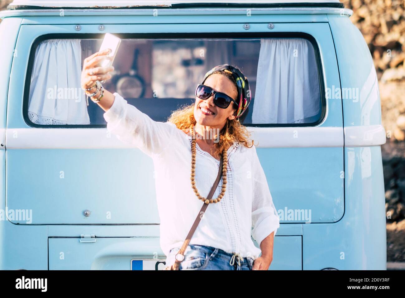 Gai belle jeune femme tendance adulte prendre photo selfie sourire et amusez-vous en plein air avec le style vintage bleu van en arrière-plan Banque D'Images