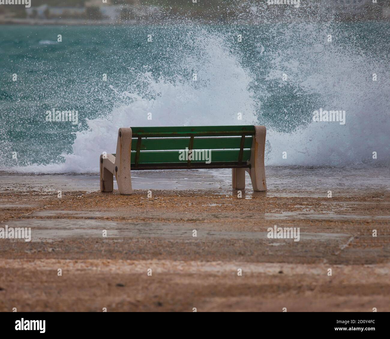 Banc solitaire sur un jour pluvieux avec jet de mer frapper la jetée. Image de stock. Banque D'Images