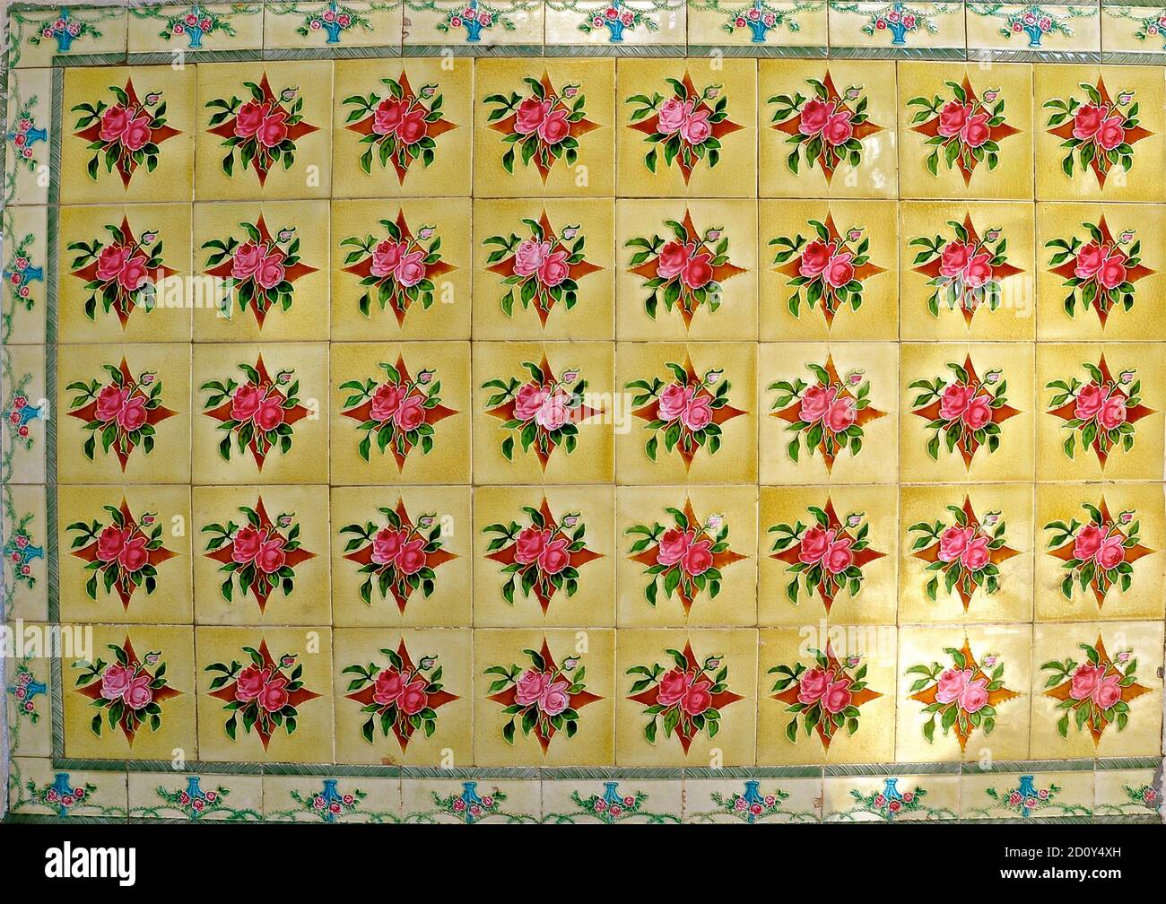 Mosaïque de carreaux jaunes décorée de fleurs rouges. Ces derniers sont typiques des carreaux que l'on trouve sur la façade des maisons traditionnelles chinoises Peranakan. Banque D'Images