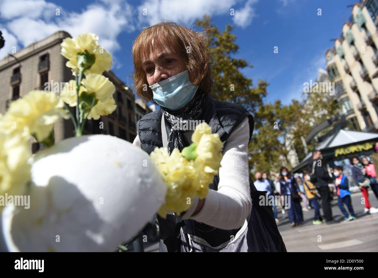 Barcelone, Espagne. 03ème octobre 2020. Une femme portant un masque prépare un bouquet de fleurs lors de la célébration du festival Roser de la Rambla. Le festival Roser a lieu chaque année sans échec depuis 1962. Les voisins de ce quartier dans le centre de Barcelone décorent des rues et des bâtiments avec des fleurs en l'honneur de la Vierge du Rosaire, Saint patron de la célèbre rue la Rambla. Crédit : SOPA Images Limited/Alamy Live News Banque D'Images