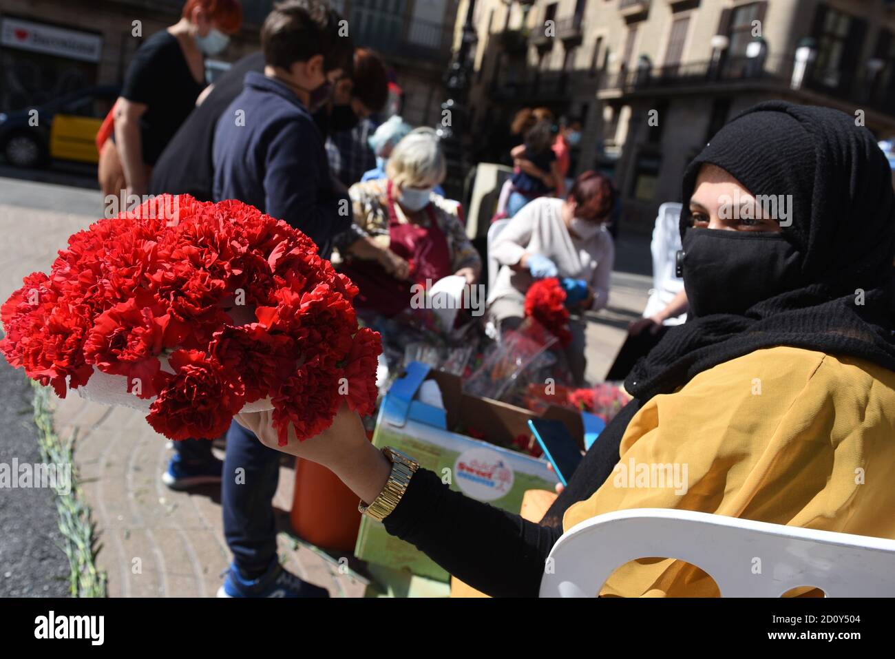 Barcelone, Espagne. 03ème octobre 2020. Une femme portant un masque pose pour une photo avec un bouquet de fleurs qu'elle a fait pendant la célébration du festival de Roser de la Rambla.le festival de Roser a lieu chaque année sans échec depuis 1962. Les voisins de ce quartier dans le centre de Barcelone décorent des rues et des bâtiments avec des fleurs en l'honneur de la Vierge du Rosaire, Saint patron de la célèbre rue la Rambla. Crédit : SOPA Images Limited/Alamy Live News Banque D'Images