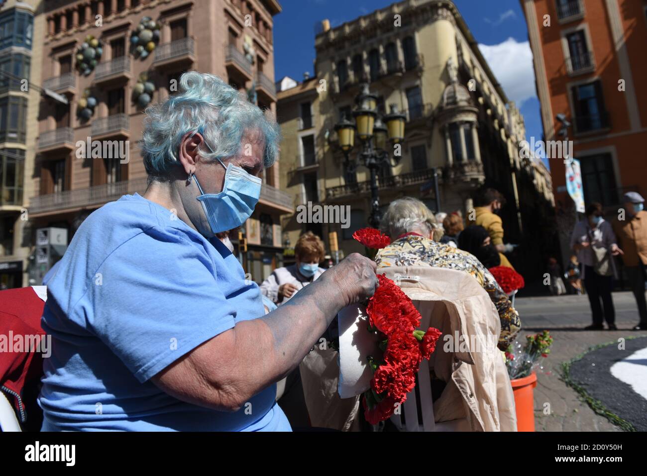 Barcelone, Espagne. 03ème octobre 2020. Une femme portant un masque prépare un bouquet de fleurs lors de la célébration du festival Roser de la Rambla. Le festival Roser a lieu chaque année sans échec depuis 1962. Les voisins de ce quartier dans le centre de Barcelone décorent des rues et des bâtiments avec des fleurs en l'honneur de la Vierge du Rosaire, Saint patron de la célèbre rue la Rambla. Crédit : SOPA Images Limited/Alamy Live News Banque D'Images