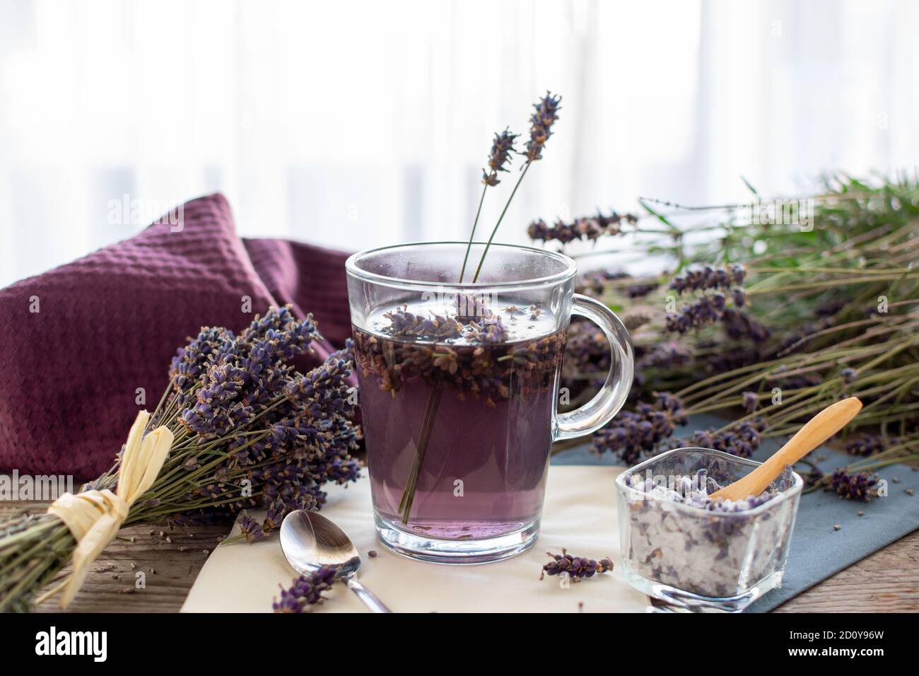 Thé de lavande rustique sur bois dans une tasse de thé en verre. La lavande (Lavandula angustifolia), a un effet calmant et antispasmodique. Banque D'Images
