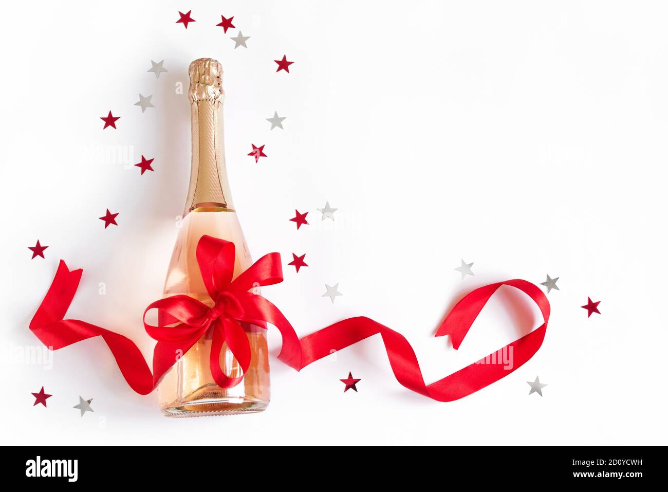 Bouteille de champagne avec noeud rouge et étoiles isolées sur fond blanc.  Campagne pour Noël ou anniversaire, vue du dessus, espace copie Photo Stock  - Alamy