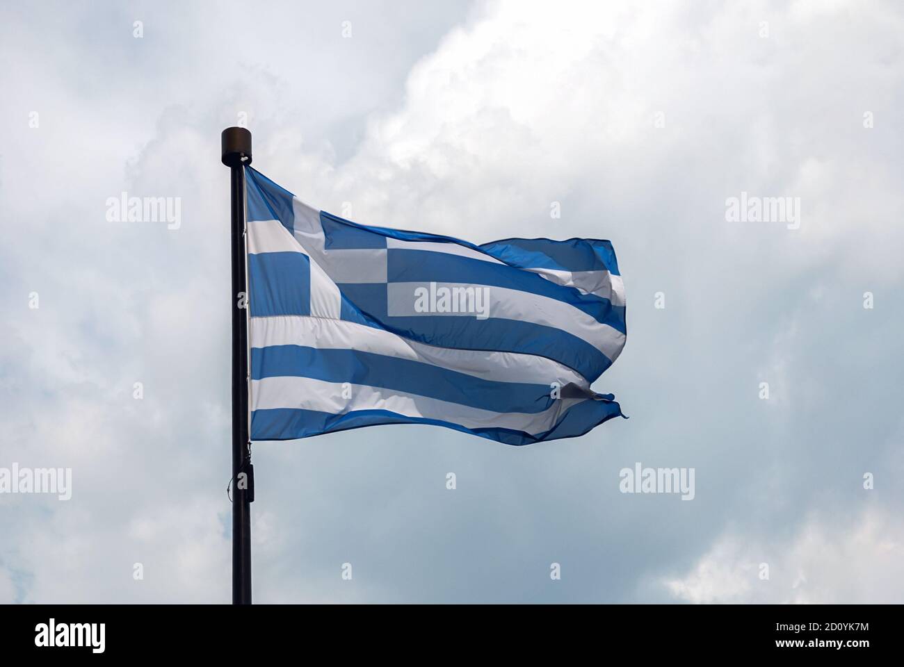 Drapeau de la Grèce sur le mât sur fond de nuages Banque D'Images