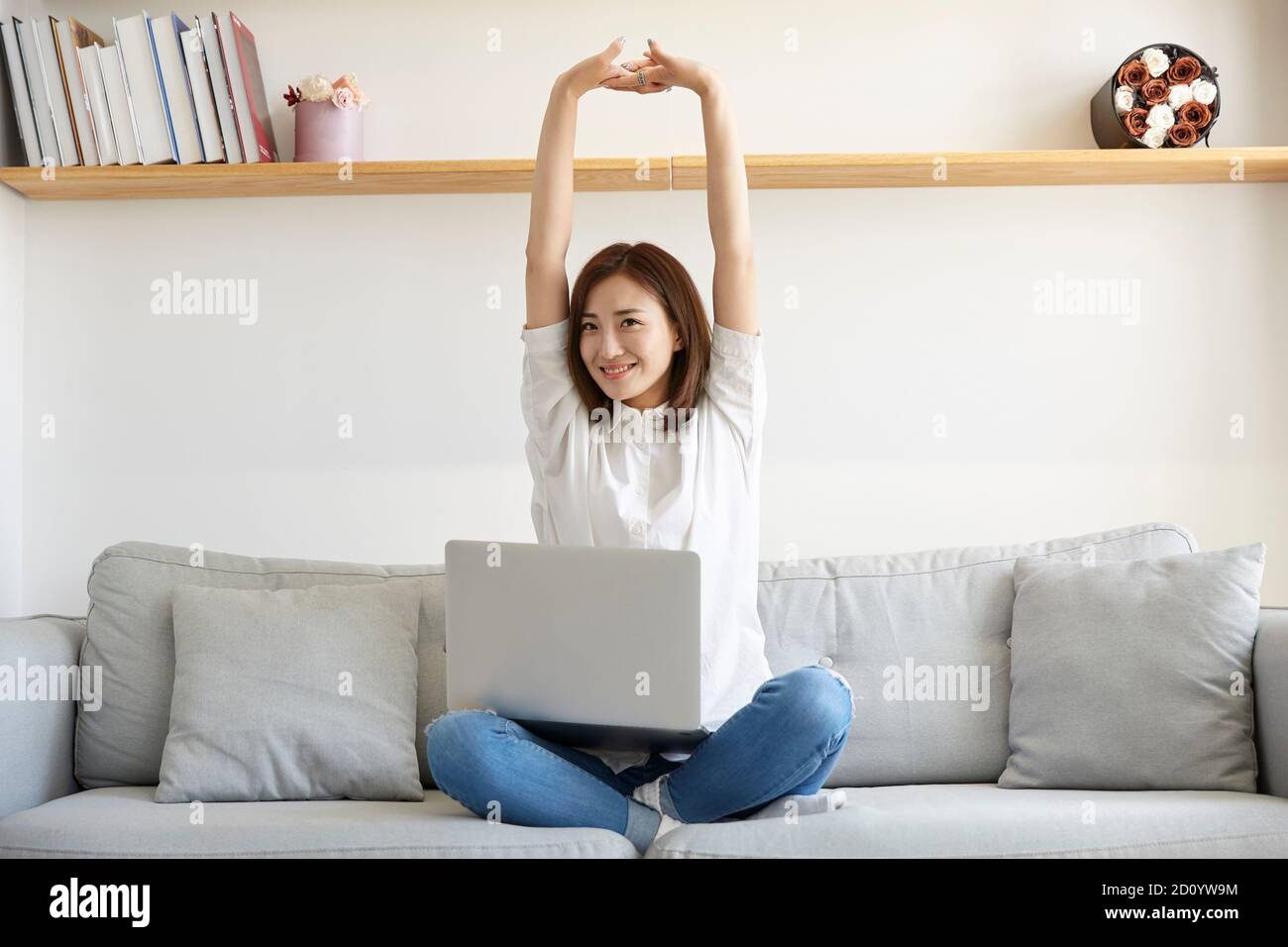 jeune femme d'affaires asiatique travaillant à domicile assise sur un canapé les bras s'étirent heureux et souriants Banque D'Images