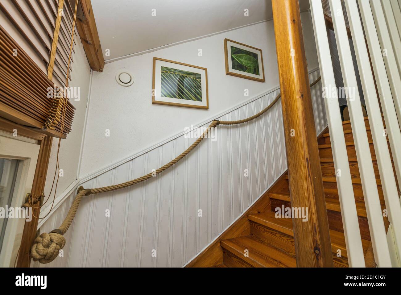 Belle vue sur les escaliers en bois avec des rampes blanches de bas en haut de l'étage. Concept intérieur. Banque D'Images