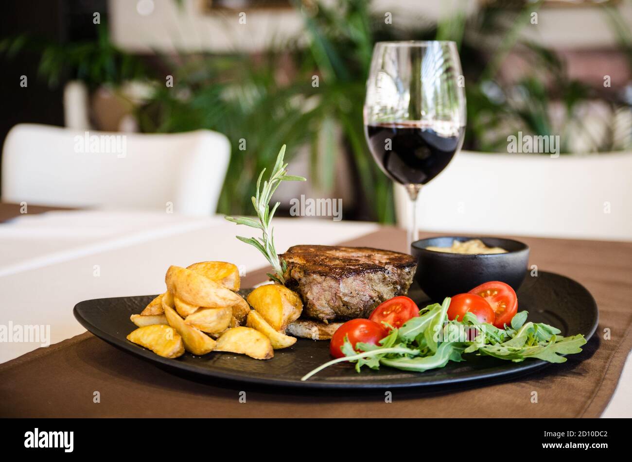 Steak de porc fraîchement préparé avec des légumes et un verre de rouge vin Banque D'Images