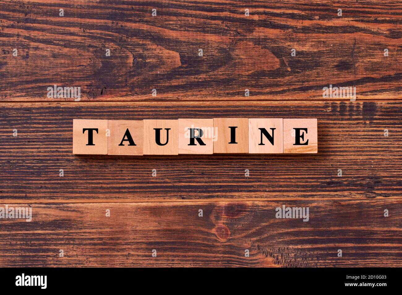 Lettrage mot taurine en cubes de bois sur fond rustique foncé en bois. La taurine aide à améliorer le métabolisme énergétique dans le corps. Foo de culturisme Banque D'Images