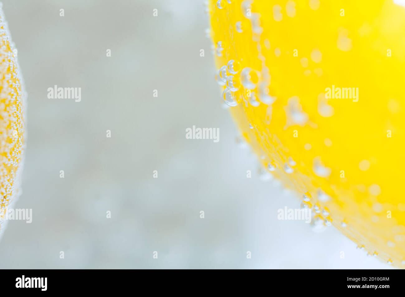 Un gros plan d'un citron, dans l'eau et la collecte de bulles d'air, créant un motif abstrait. Banque D'Images