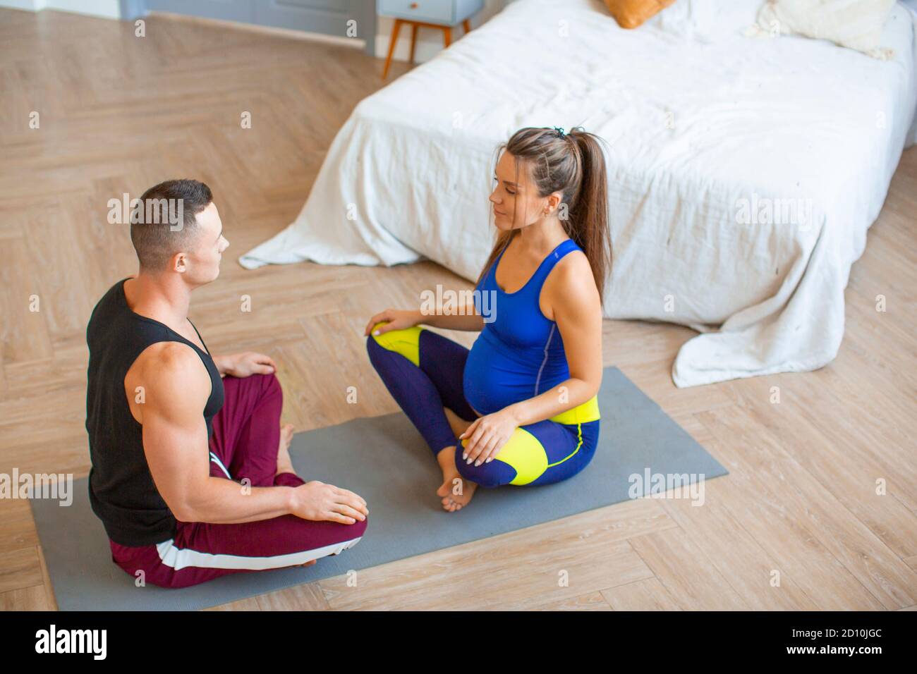 Couple. Femme enceinte et son mari méditant à la maison. Concept de soins de santé. Banque D'Images