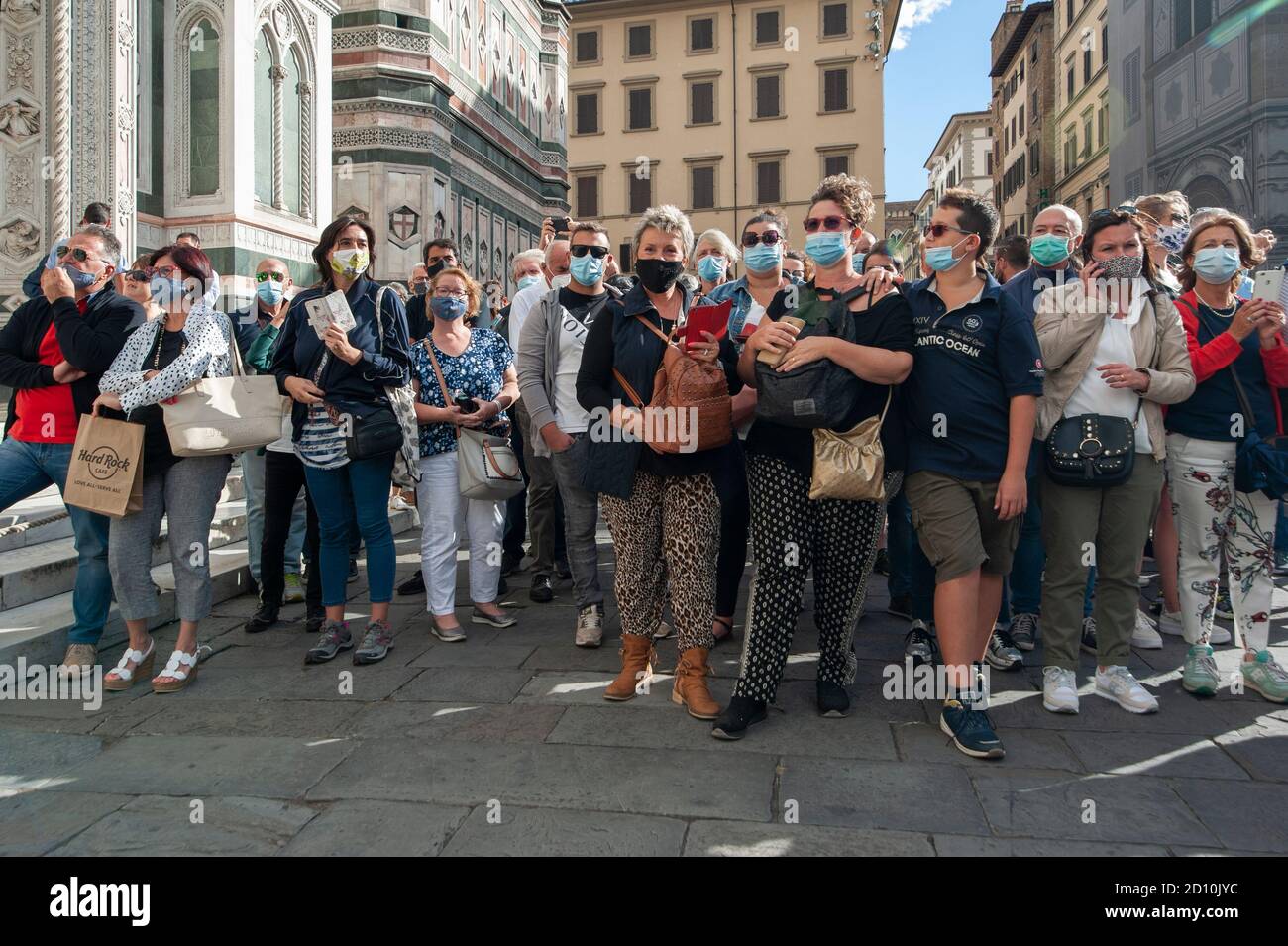 Florence, Italie - 2020, septembre 26: Touristes (personnes non identifiées) portant un masque facial et prend des photos avec téléphone dans la rue, pendant le coronavirus. Banque D'Images