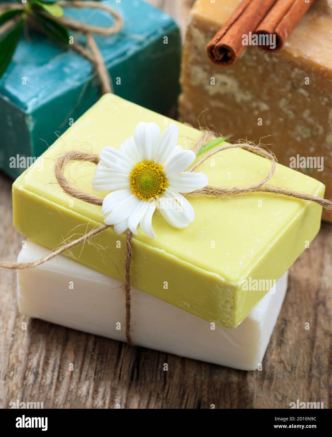 Savons de camomille faits maison. Porte-savon artisanal de couleur blanche et jaune, vue rapprochée. Cosmétiques naturels et sains à base de plantes Banque D'Images