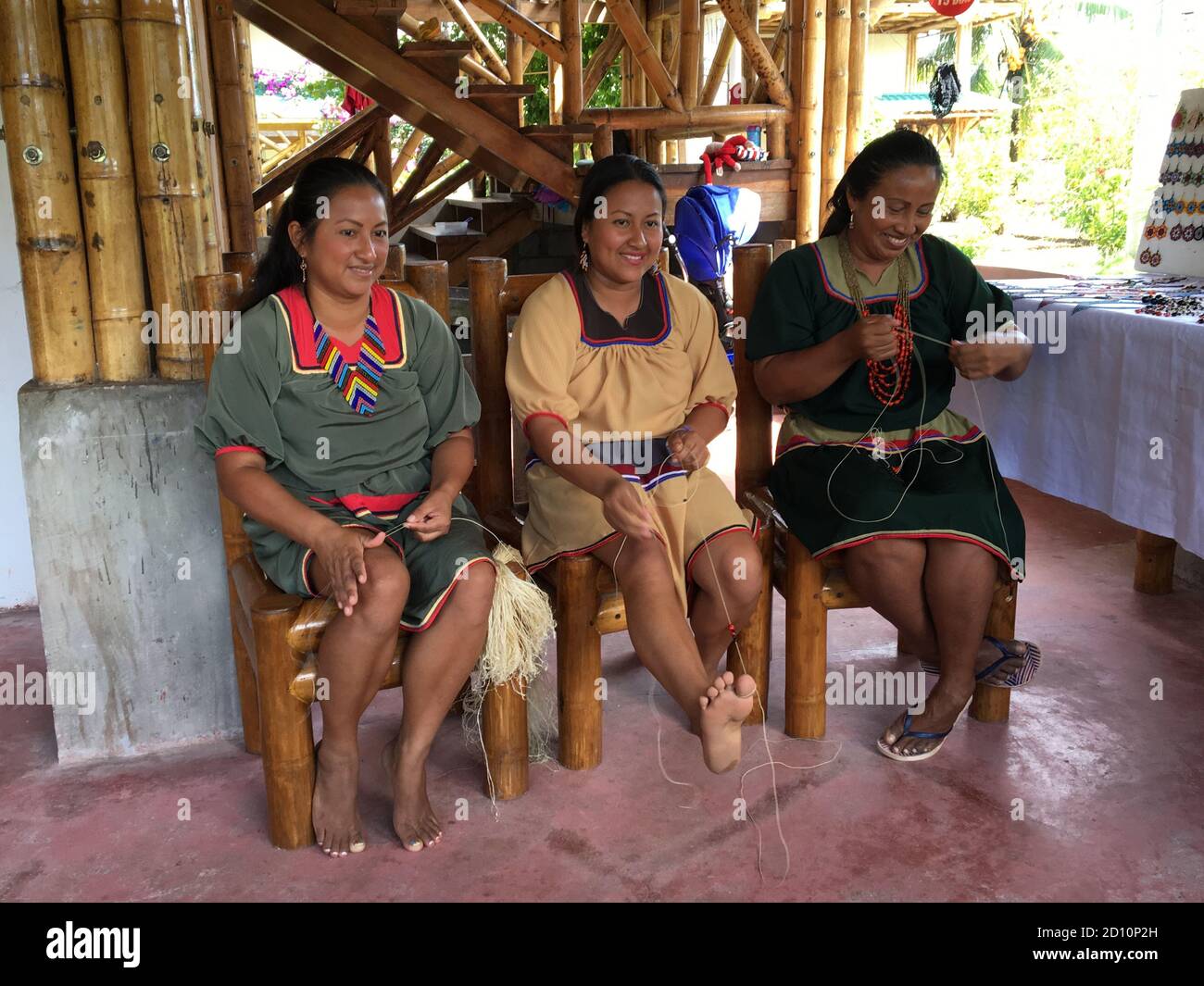 Nueva Loja, Sucumbios / Equateur - 2 septembre 2020: Groupe de trois femmes autochtones de nationalité cofan qui tissage de l'artisanat dans leur maison dans l'AMAZ Banque D'Images