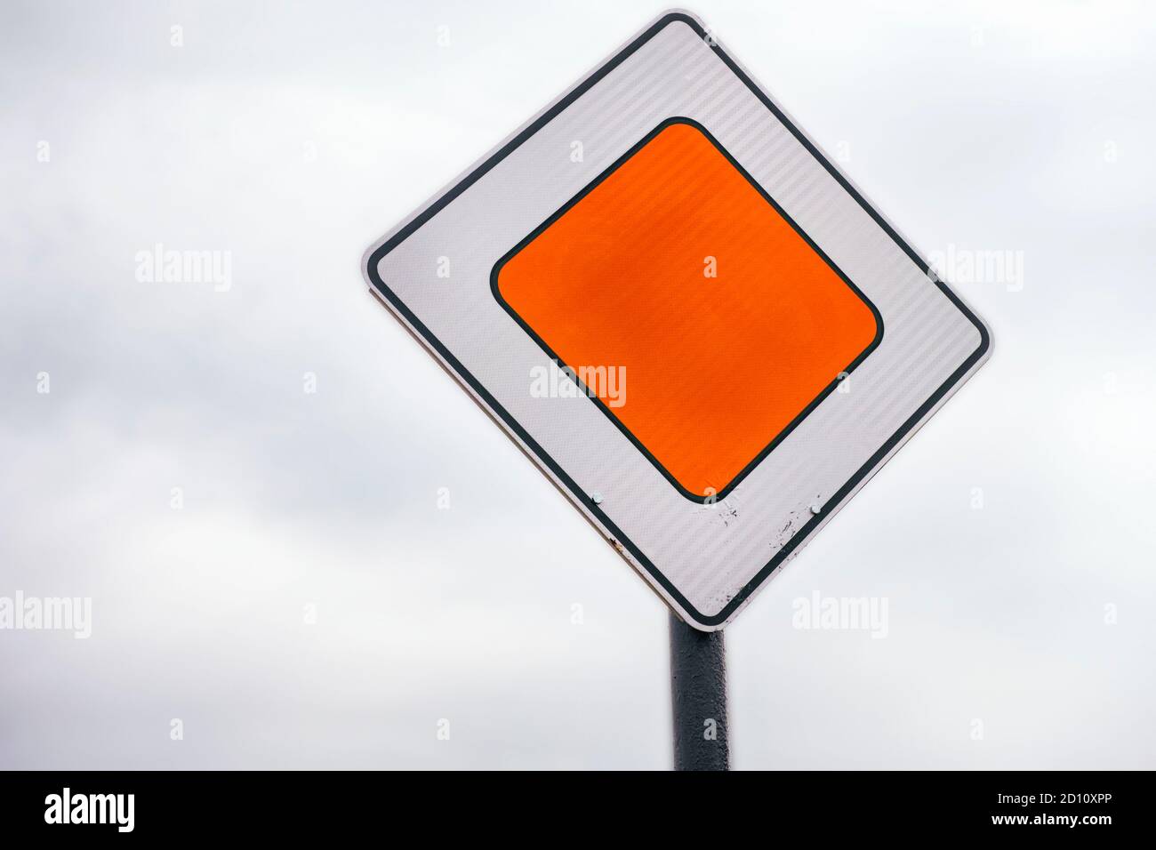 Un panneau routier moderne Priority contre ciel nuageux Banque D'Images