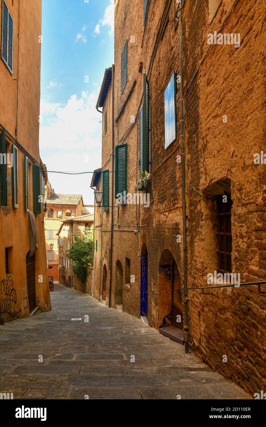 Aperçu d'une ruelle étroite dans le centre historique de Sienne, site classé au patrimoine mondial de l'UNESCO, avec les anciennes façades de briques typiques, Toscane, Italie Banque D'Images