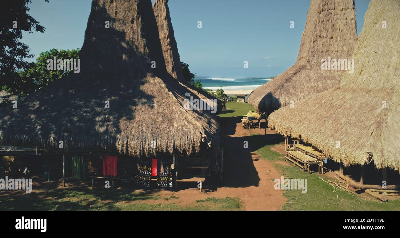 Gros plan maisons traditionnelles avec des toits ornately au village de campagne verte. Extérieur de peuplement primitif avec longue tradition à l'île de Sumba, Indonésie, Asie. Prise de vue en lumière douce de qualité cinématographique Banque D'Images