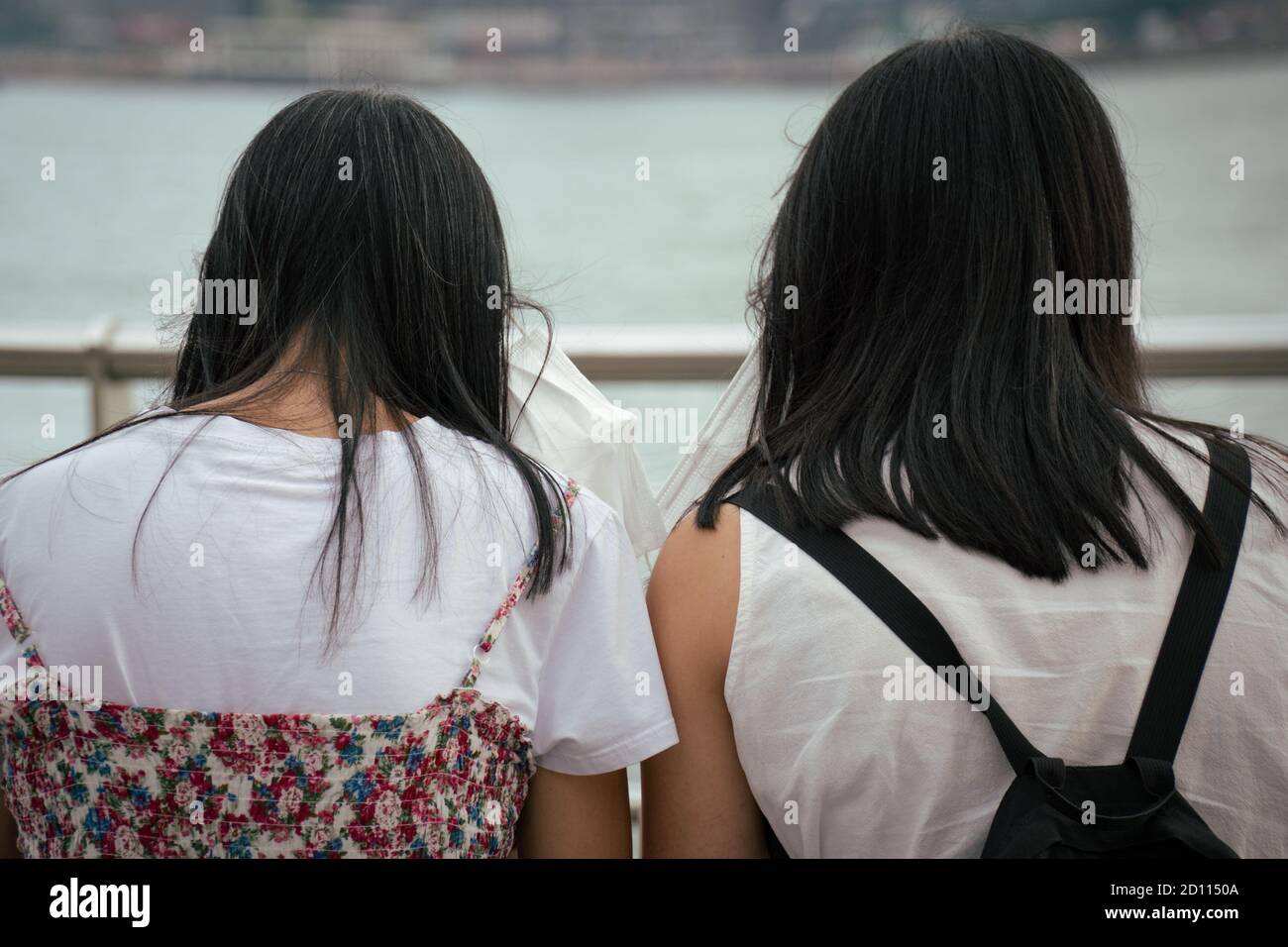 Les femmes prennent leur masque autour de la promenade Tsim Sha Tsui.le gouvernement exige le port obligatoire de masques faciaux lors de l'utilisation des transports publics, ainsi que des lieux publics intérieurs et extérieurs, sauf lors de l'exercice ou de la randonnée à l'extérieur et dans les parcs de campagne. Banque D'Images