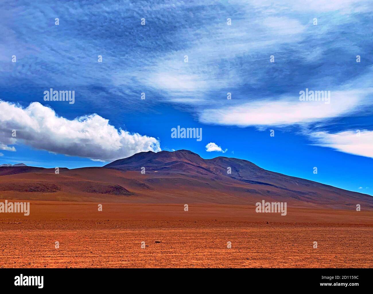 Andes montagnes volcaniques dans le désert. Nature sauvage en Bolivie, Amérique du Sud. Paysage de nuages pittoresques dans le ciel bolivien. Terrain Uni rouge. Banque D'Images