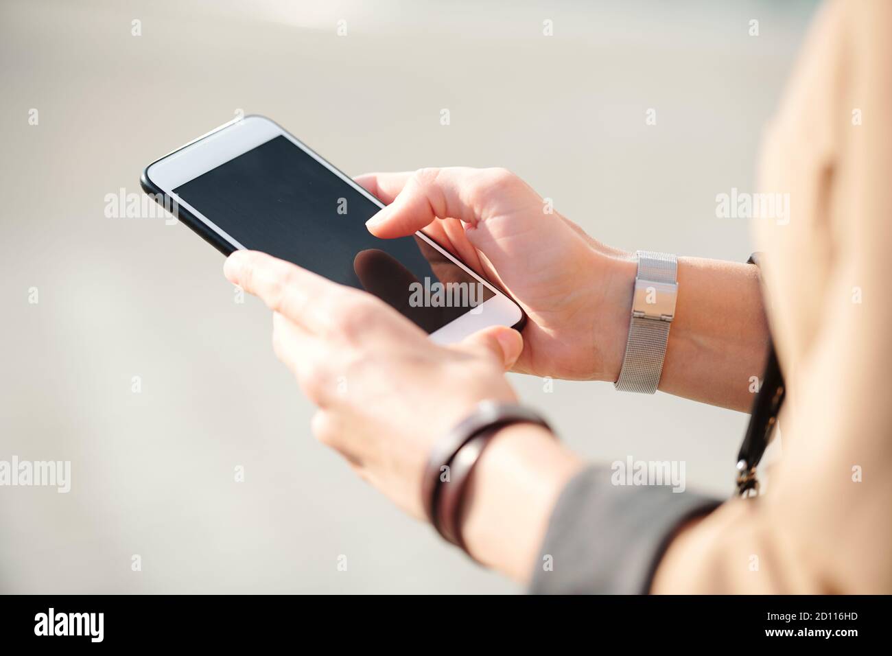 Les mains de la jeune femme d'affaires élégante avec smartphone défilant dans les contacts Banque D'Images