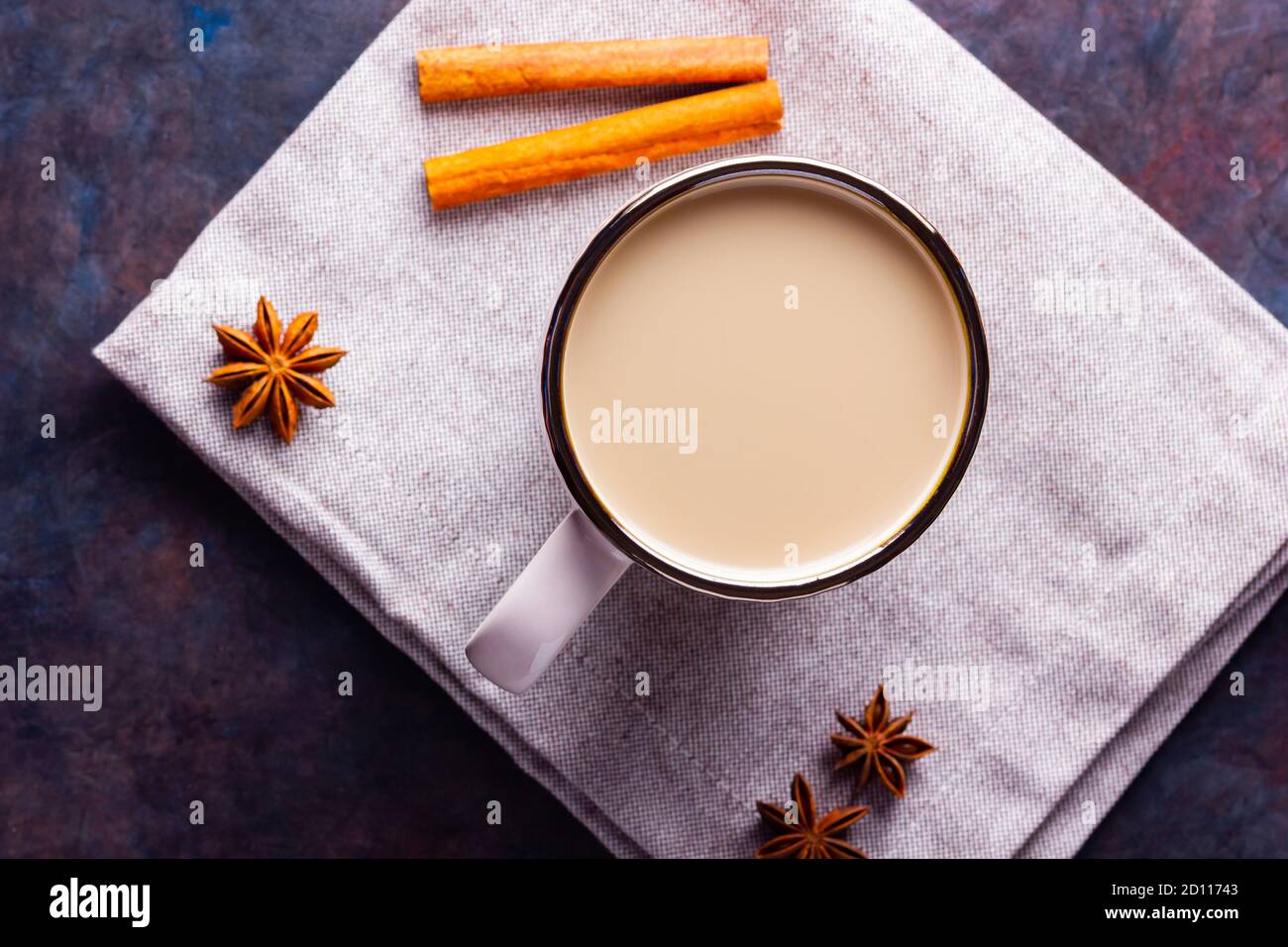 Thé Chai de masala. Boisson traditionnelle indienne - thé masala avec épices sur fond noir. Tasse en céramique d'épices thé sur serviette en lin Banque D'Images