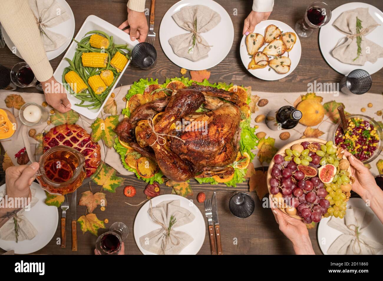 Vue des mains des membres de la famille qui tiennent des assiettes avec maison nourriture sur table Banque D'Images
