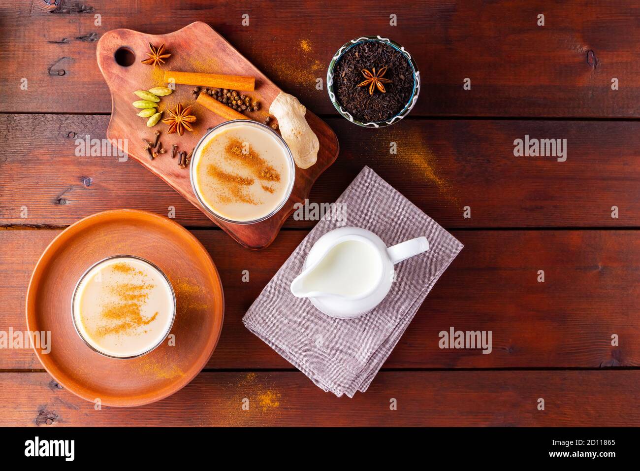 Deux verres de thé masala et divers ingrédients. Thé Chai au masala sur des planches en bois. Thé au lait et épices. Copier l'espace. Vue de dessus Banque D'Images
