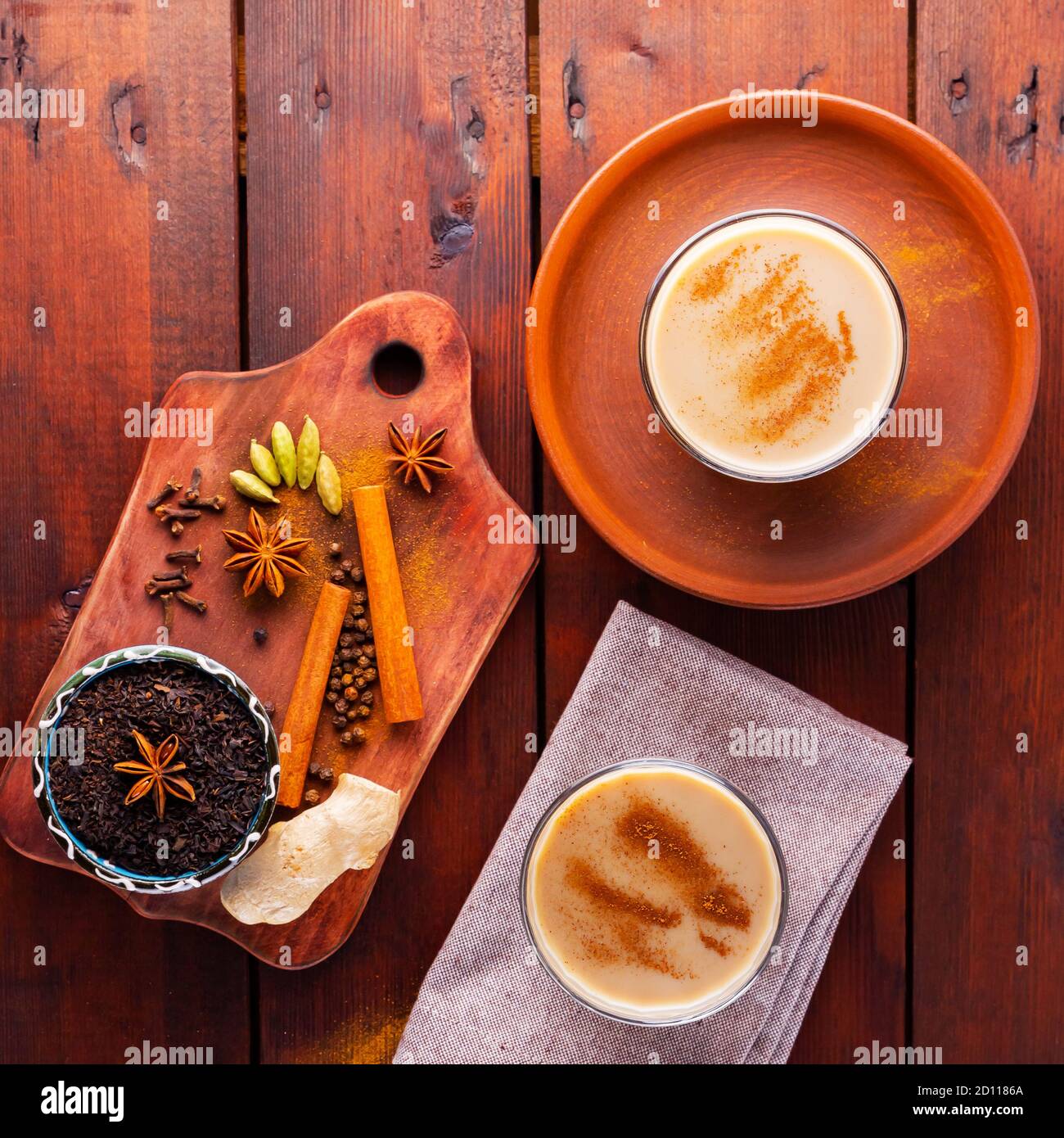 Deux verres de thé masala et divers ingrédients. Thé Chai au masala sur des planches en bois. Thé au lait et épices. Copier l'espace. Vue de dessus Banque D'Images