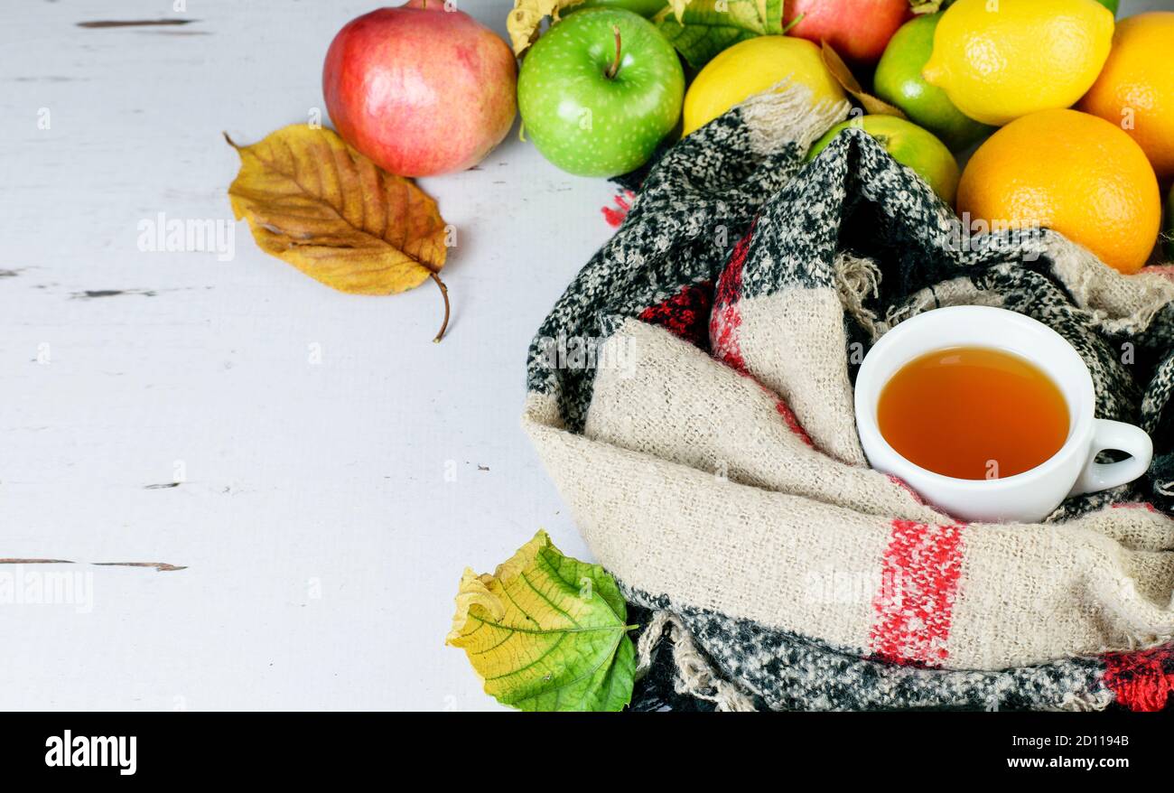 Tasse de thé aux fruits, foulard chaud, agrumes fruits tropicaux comme symboles de remède anti-virus, système immunitaire de rappel. Banque D'Images