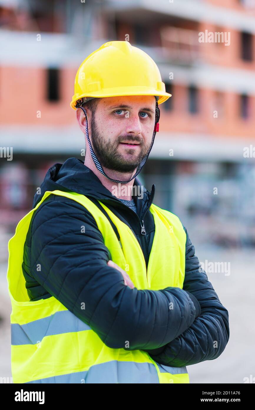Un ingénieur qui se pose devant la construction du bâtiment, il est fonctionnement de Banque D'Images