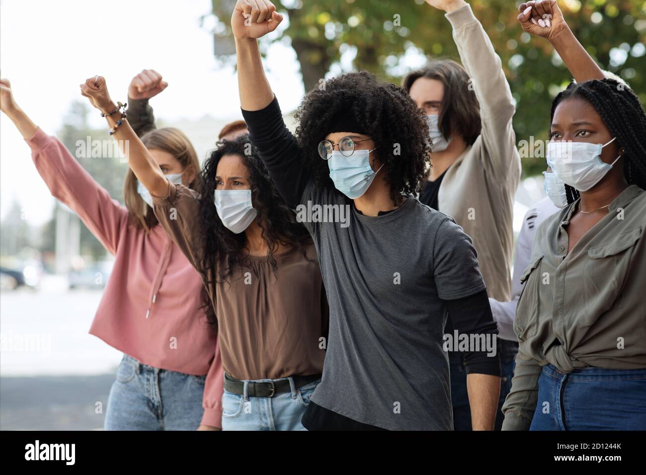 Les étudiants portant un masque facial protecteur protestent et élèvent les poings Banque D'Images