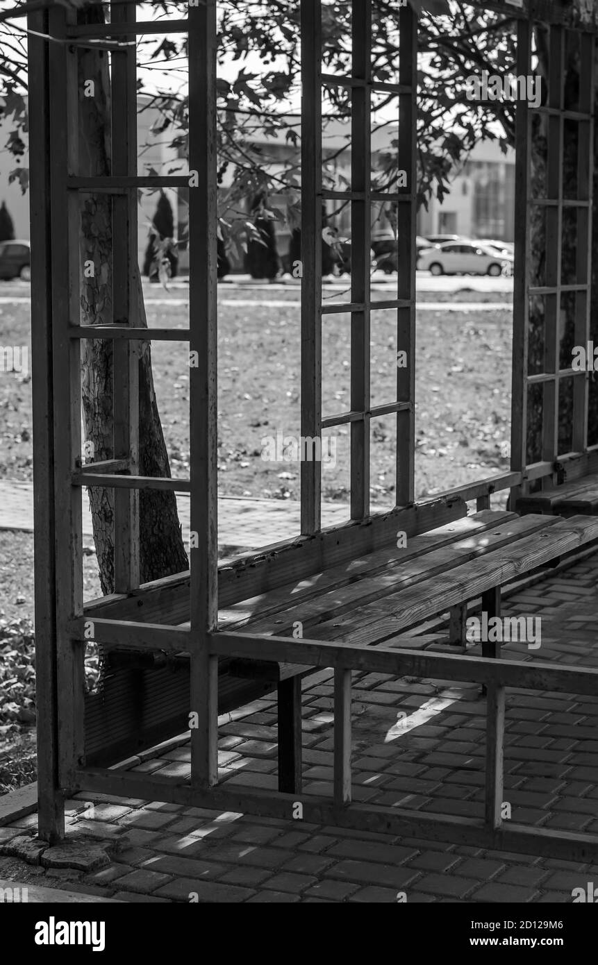 Arrêt de bus vide avec bancs en bois. Photo en noir et blanc d'un arrêt de bus de banlieue. Transports en commun. Concept de voyage. Sans personne Banque D'Images