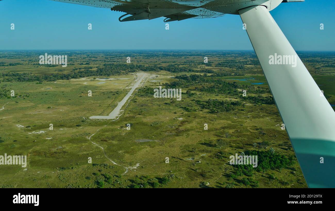 Vue aérienne d'un aérodrome isolé entouré de terres du Bush dans le delta d'Okavango, Maun, Botswana depuis l'avion. Banque D'Images