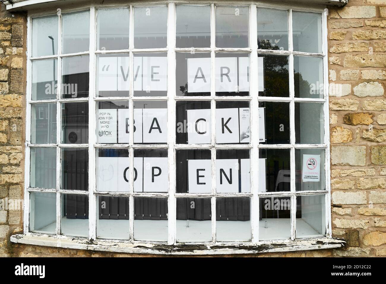 Avis « nous sommes de retour - ouvert » dans une vitrine à Corby Old village, Northamptonshire, Angleterre, pendant la pandémie du coronavirus, octobre 2020. Banque D'Images