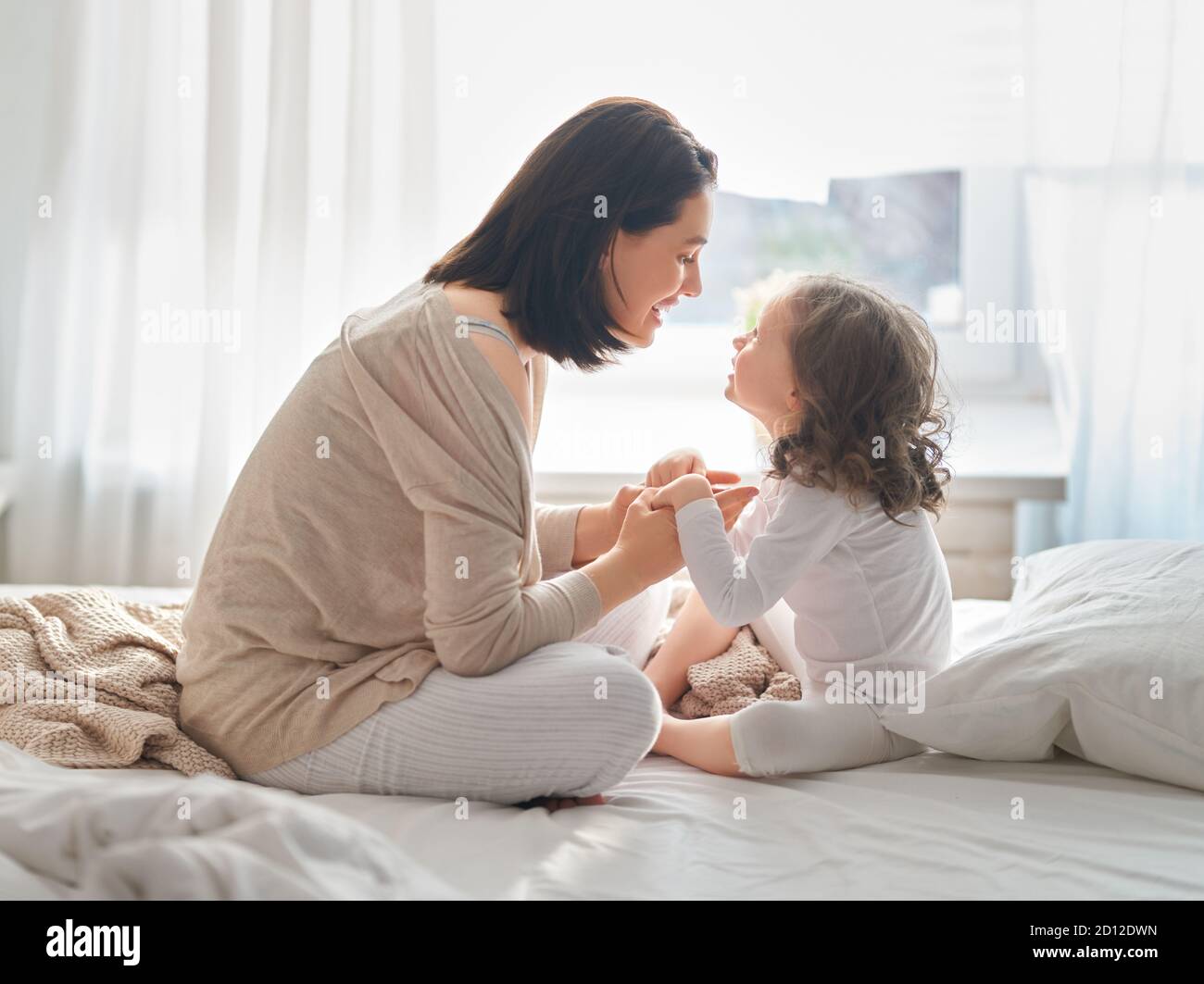 Une belle fille et sa mère aiment le soleil matin. Bon séjour à la maison. L