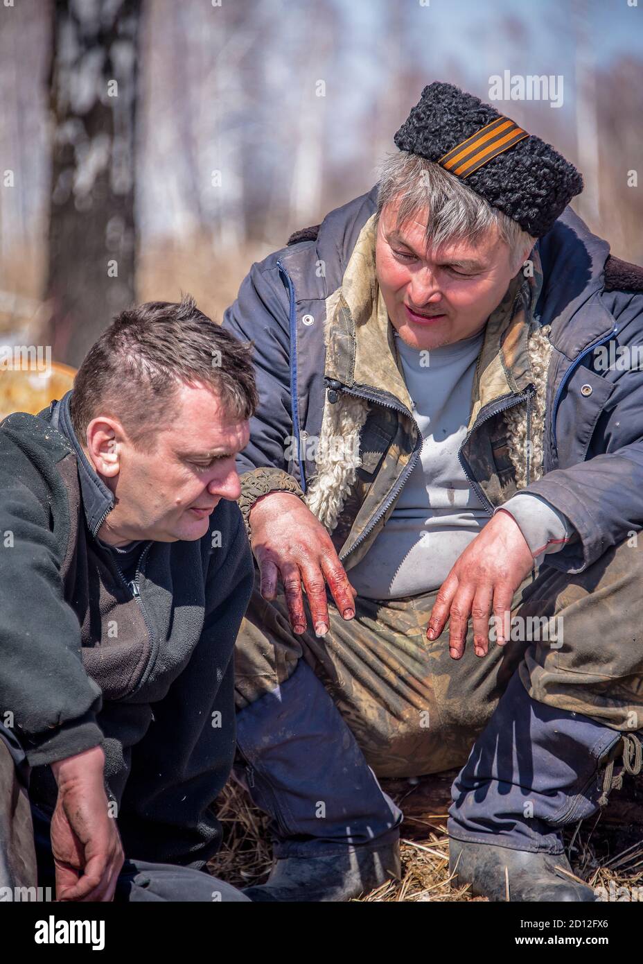 Deux chasseurs parlent dans un défrichement forestier se reposant après la coupe jeu Banque D'Images