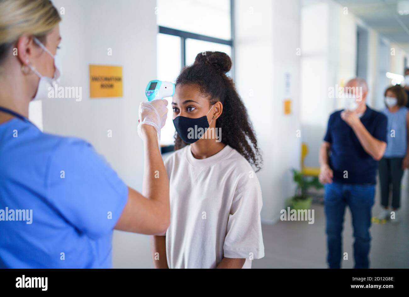 Personnes avec masques faciaux, coronavirus, covid-19, mesure de la température et concept de vaccination. Banque D'Images