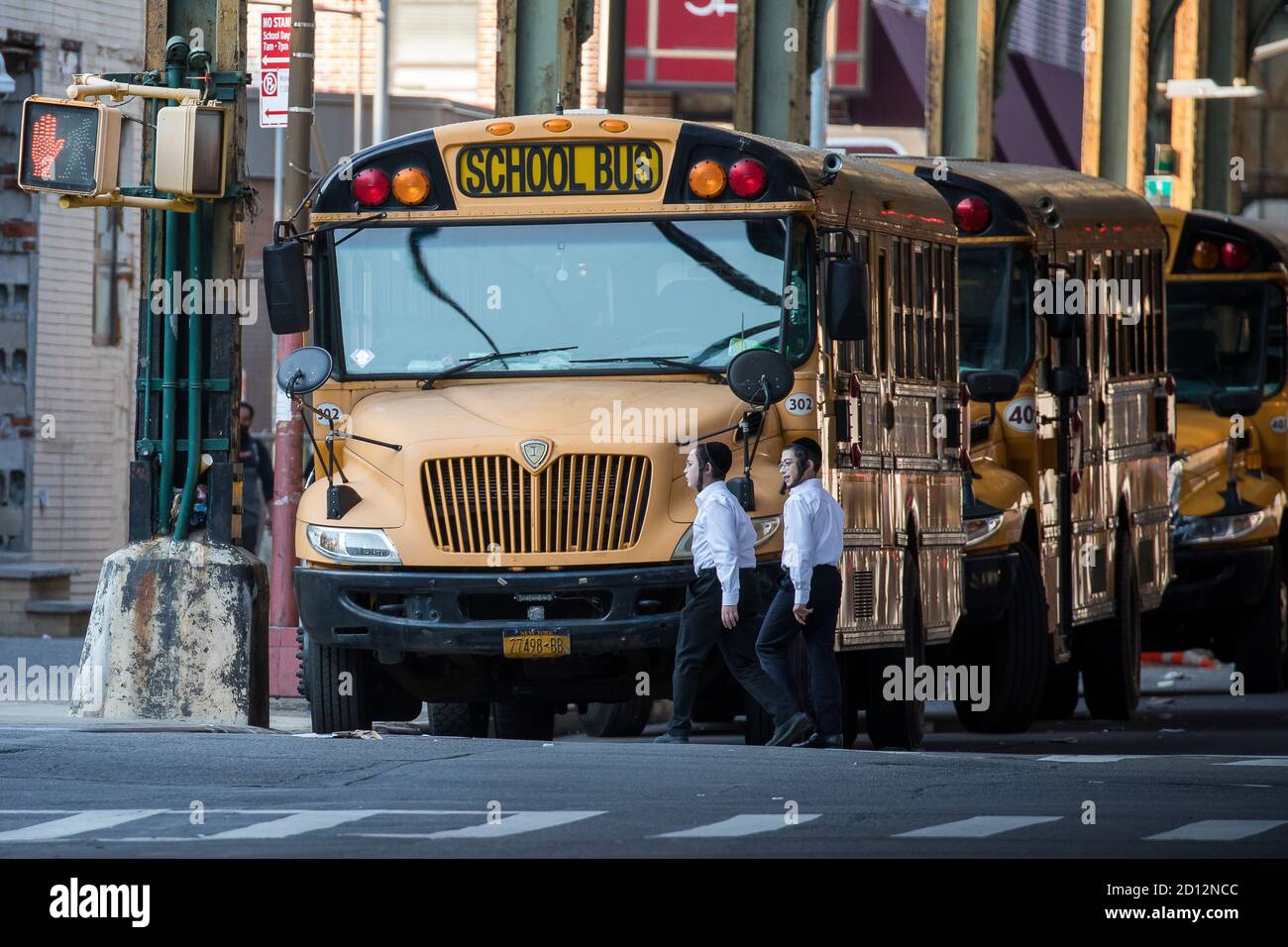 New York, États-Unis. 4 octobre 2020. Les enfants passent devant les autobus scolaires dans le quartier de Borough Park, dans le quartier de Brooklyn, New York, aux États-Unis, le 4 octobre 2020. Le maire de la ville de New York, Bill de Blasio, a annoncé dimanche une proposition visant à « fermer TOUTES les écoles et les entreprises non essentielles » dans neuf zones de code postal de la ville, le 7 octobre, en raison de l'augmentation des cas de COVID-19 enregistrés. Credit: Michael Nagle/Xinhua/Alay Live News Banque D'Images