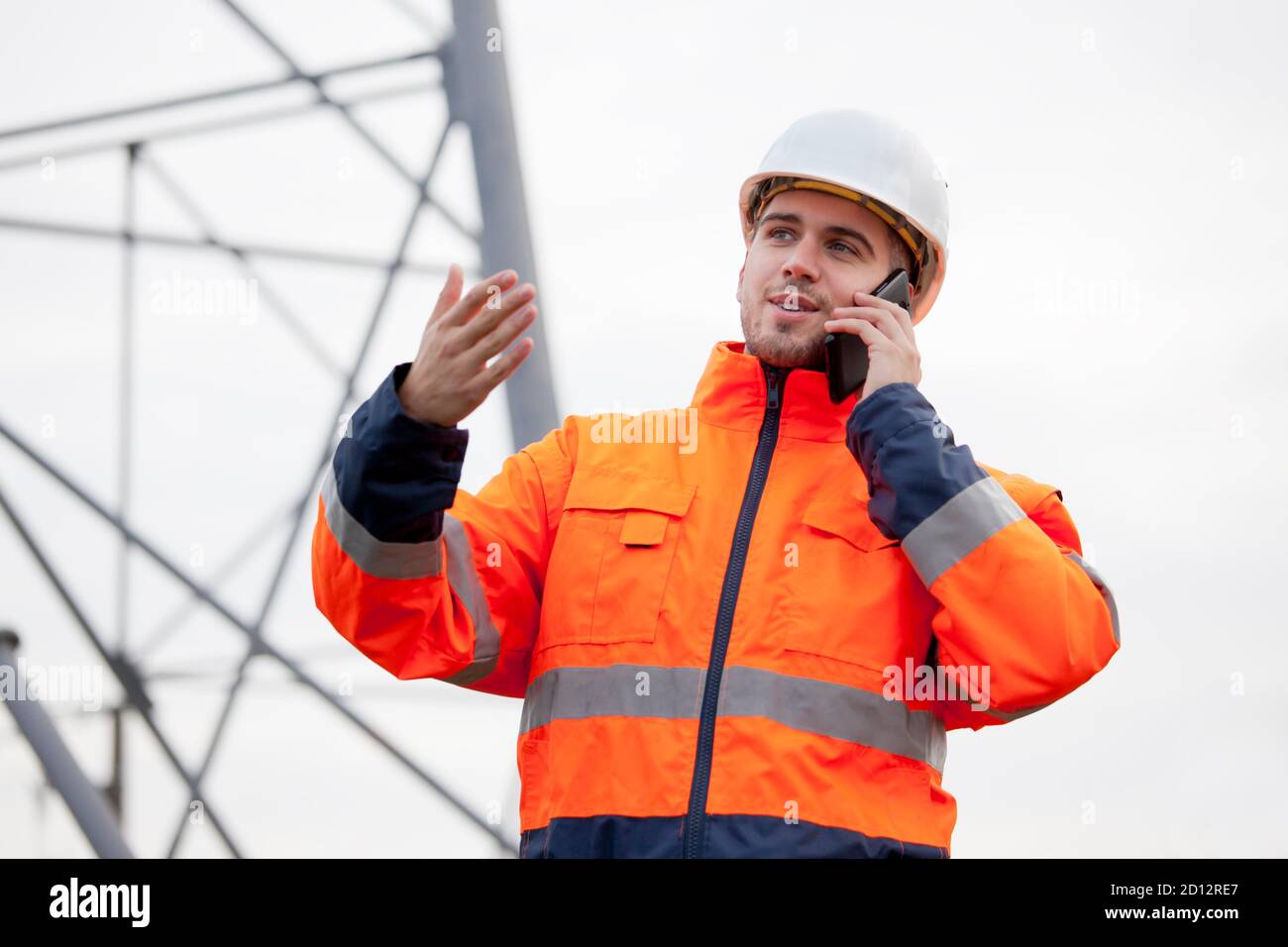 Jeune ingénieur ou contremaître parlant sur un smartphone sur un plate-forme pétrolière ou chantier de construction - attention sélective Banque D'Images