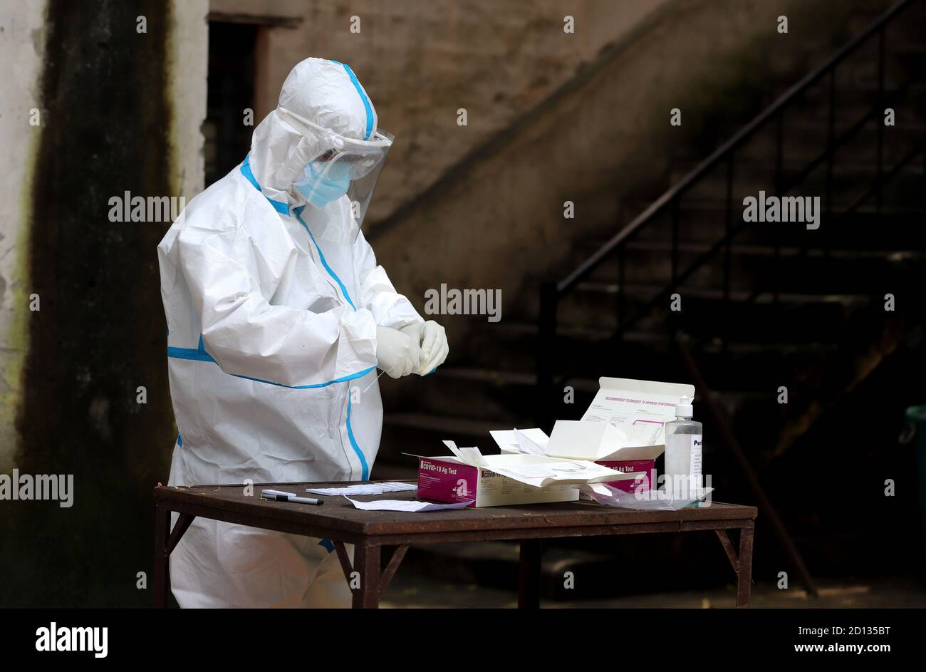 Un personnel médical prélève un échantillon par écouvillonnage d'une personne suspecte du coronavirus dans un centre de test de fortune Covid-19 à New Delhi. Banque D'Images