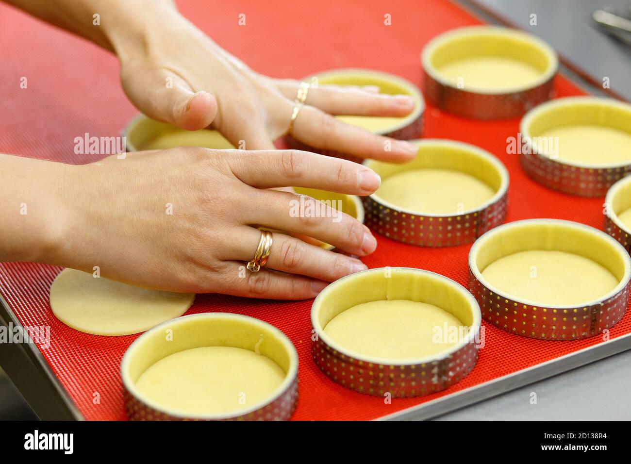 Préparer des tartes et des quiches sucrées ou salées. Cuisine nationale française. Fait à la main. Formation à la cuisine. Le cuisinier remplit le plat de cuisson avec la garniture. C Banque D'Images